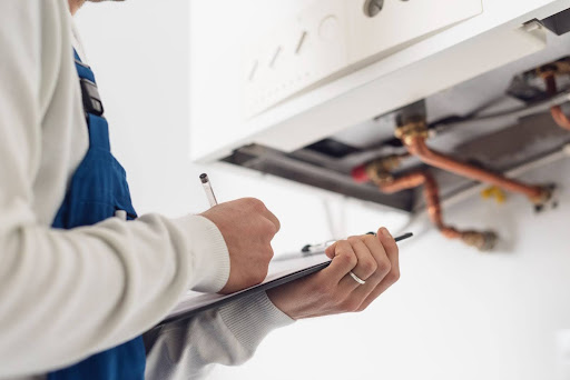 HEATING ENGINEER CONDUCTING A BOILER INSPECTION FOR SERVICING